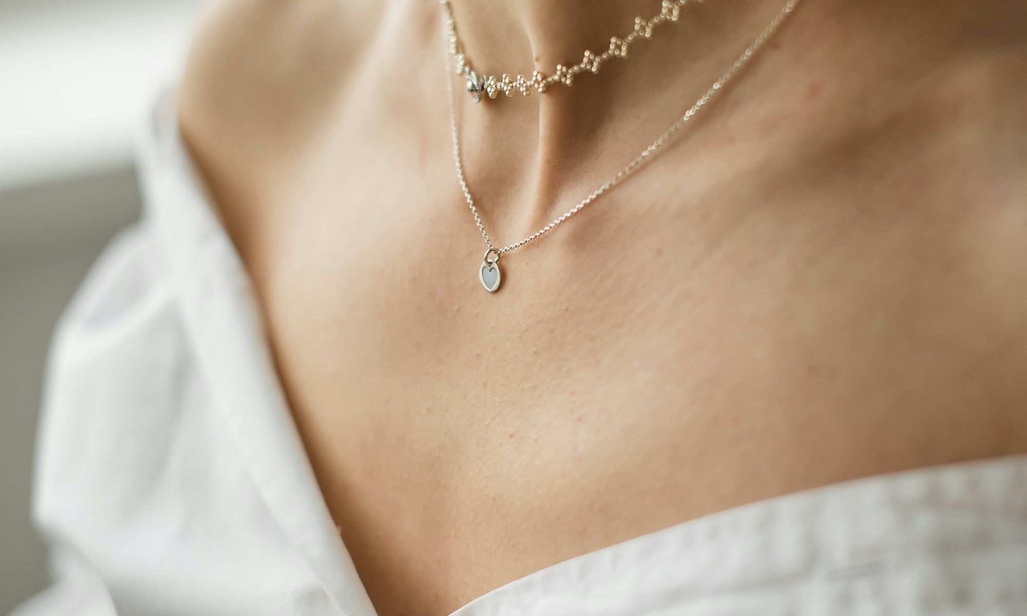 Model wearing a silver necklace in soft natural light